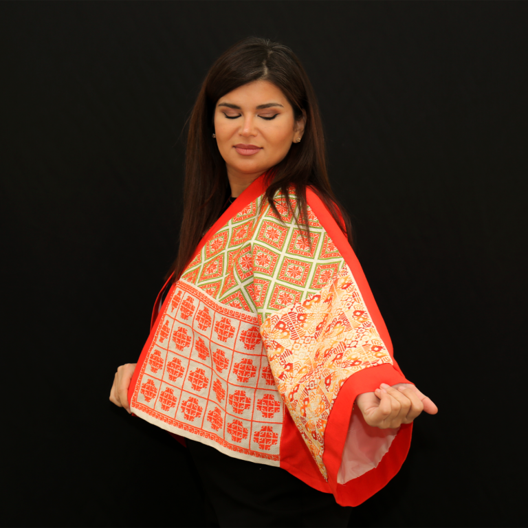 Woman wearing a mid-length kimono with an earth-tone mosaic pattern by The Studio NGO.