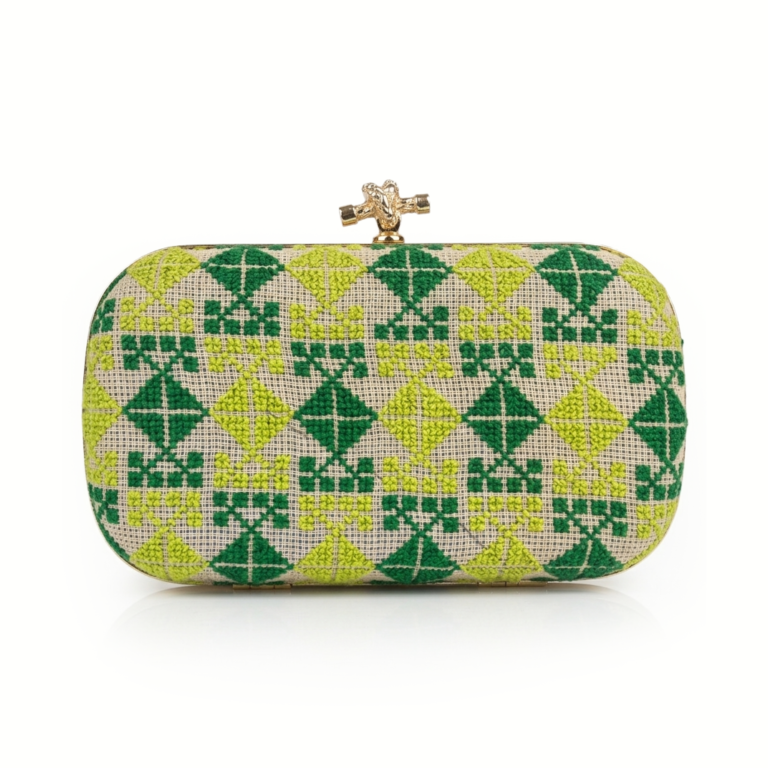 Luxury rectangular box clutch featuring intricate green and lime Palestinian Tatreez embroidery on a neutral woven linen base with a gold knot clasp closure.