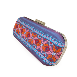 Hand-embroidered purple silk evening clutch featuring traditional orange and pink Tatreez geometric patterns.